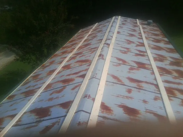 Rusted metal roof panels with new wood purlins before replacement — Storm Damage Roof Repair in Artesia by Roofing Brothers