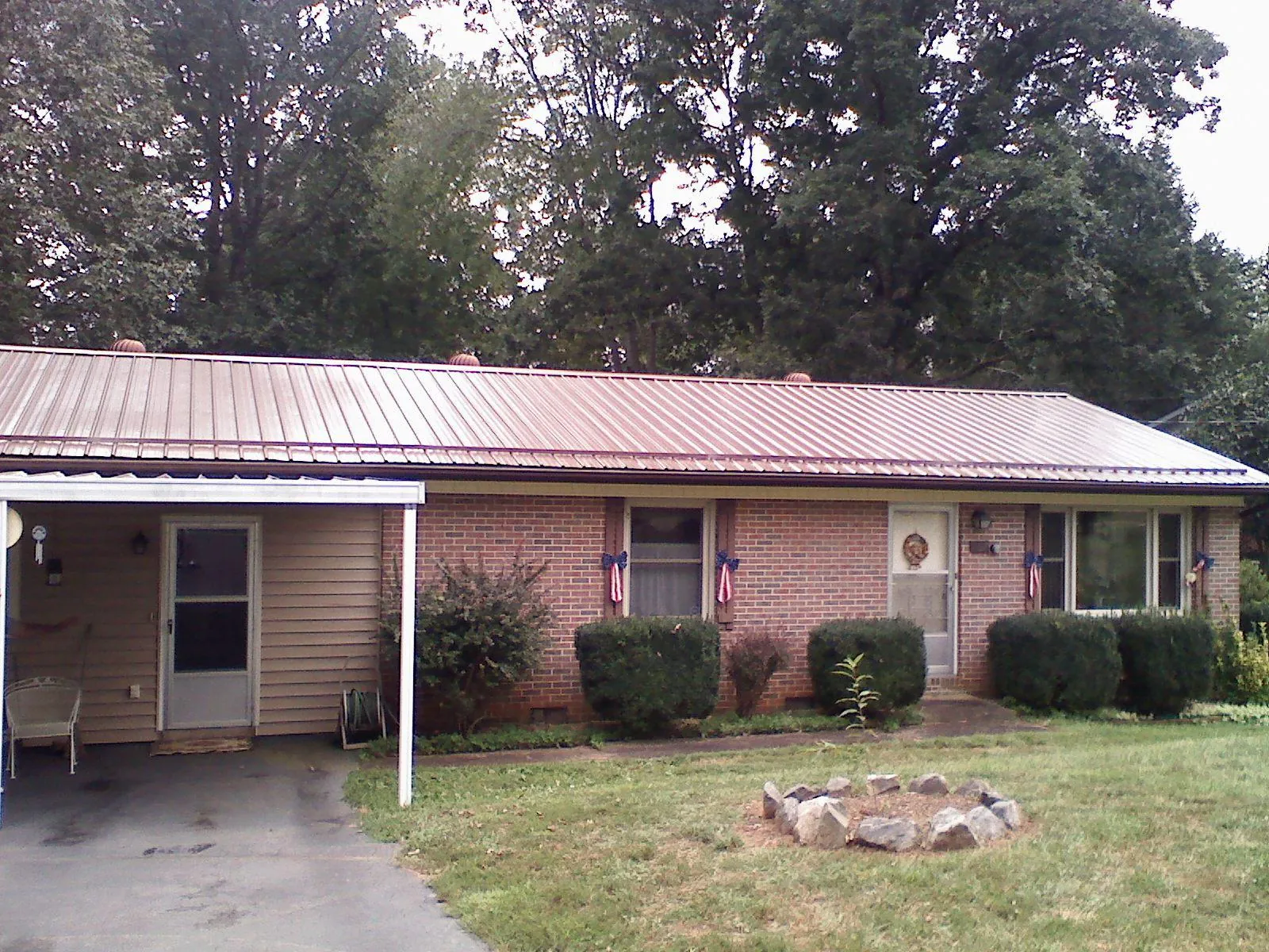 Bronze metal roof and carport on a brick ranch home — Roof Repair work by our crew in Artesia